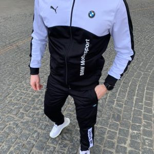 Чоловічий спортивний костюм PUMA BMW Motorsport чорного кольору з білими логотипами, демонструє якість та стиль. Модель на чоловіку, підкреслюючи спортивний силует та комфорт для повсякденного носіння та активного відпочинку. Ідеально для фанатів автоспорту.