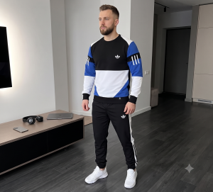 Чоловічий спортивний костюм Urban Classic чорного кольору, що складається з куртки на блискавці та штанів, на моделі, що стоїть на вулиці