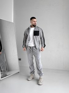 Зимовий чоловічий спортивний костюм Move світло-сірого кольору з турецького флісу полар, вид спереду на моделі, демонструються 5 кишень на блискавках та капюшон.