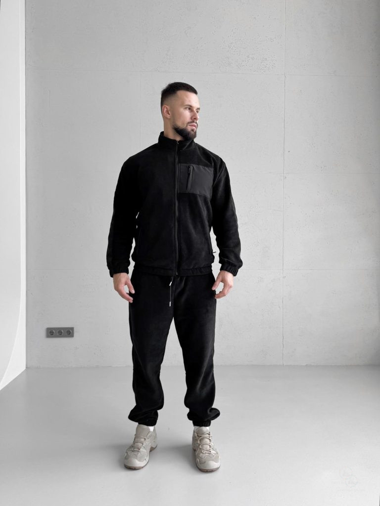 Чорний зимовий чоловічий костюм Move з флісу полар, що демонструє функціональні кишені на блискавках та щільний матеріал. Вид спереду на моделі.