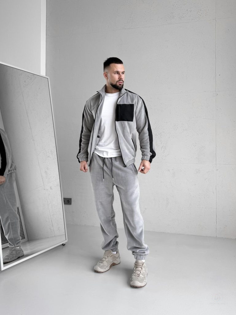 Зимовий чоловічий спортивний костюм Move світло-сірого кольору з турецького флісу полар, вид спереду на моделі, демонструються 5 кишень на блискавках та капюшон.