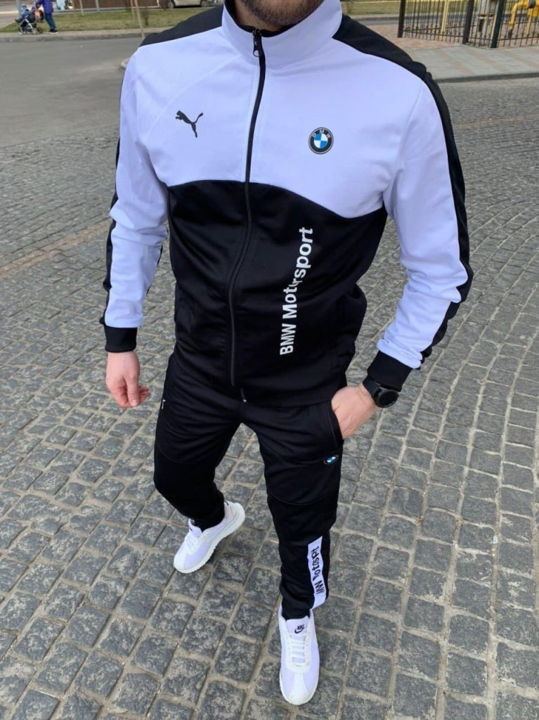 Чоловічий спортивний костюм PUMA BMW Motorsport чорного кольору з білими логотипами, демонструє якість та стиль. Модель на чоловіку, підкреслюючи спортивний силует та комфорт для повсякденного носіння та активного відпочинку. Ідеально для фанатів автоспорту.