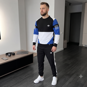 Чоловічий спортивний костюм Urban Classic чорного кольору, що складається з куртки на блискавці та штанів, на моделі, що стоїть на вулиці