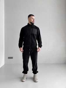 Чорний зимовий чоловічий костюм Move з флісу полар, що демонструє функціональні кишені на блискавках та щільний матеріал. Вид спереду на моделі.