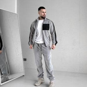 Зимовий чоловічий спортивний костюм Move світло-сірого кольору з турецького флісу полар, вид спереду на моделі, демонструються 5 кишень на блискавках та капюшон.